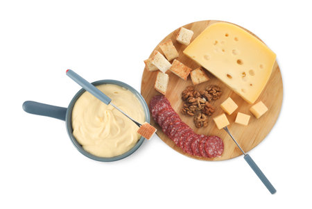 Fondue with tasty melted cheese, forks and different snacks isolated on white, top viewの写真素材