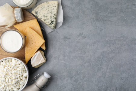 Different fresh dairy products on gray table, top view. Space for textの写真素材