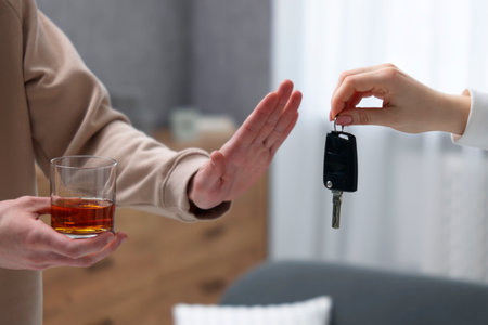 Drunk man refusing to drive car while woman offering him keys, closeup. Don't drink and drive...