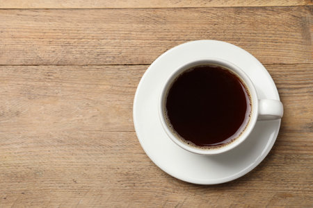 Cup of aromatic coffee on wooden table, top view. Space for textの写真素材