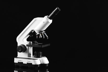 Modern microscope on black mirror surface, space for textの写真素材