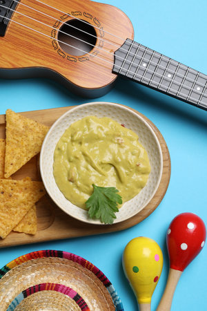 Flat lay composition with Mexican sombrero hat and guacamole on light blue backgroundの写真素材