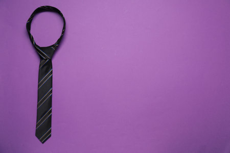 Striped necktie on purple background, top view. Space for textの写真素材