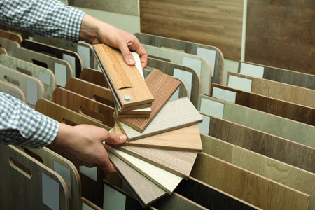 Man with samples of wooden flooring in shop, closeupの写真素材