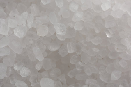 White natural salt as background, top view