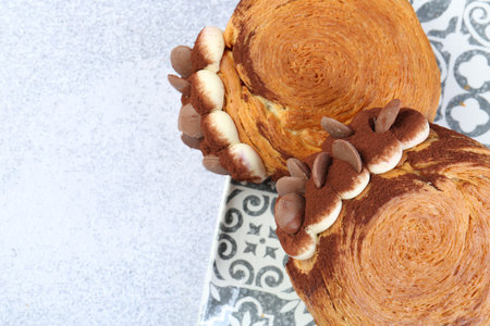 Tasty puff pastry. Supreme croissants with chocolate chips and cream on gray table, above view....