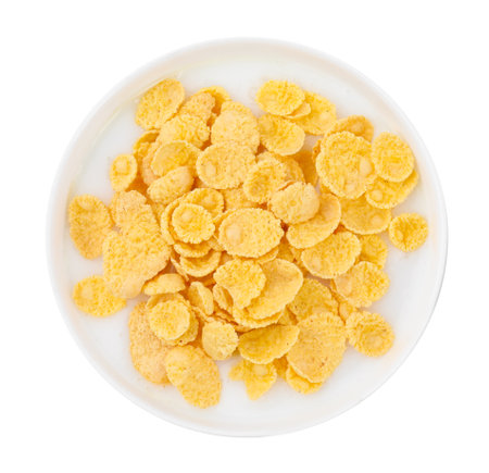Breakfast cereal. Corn flakes and milk in bowl isolated on white, top viewの写真素材