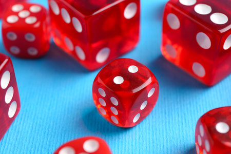 Many red game dices on light blue background, closeupの写真素材