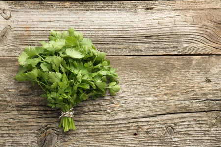 Bunch of fresh coriander on wooden table, top view. Space for textの写真素材