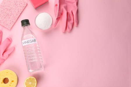 Eco friendly natural cleaners. Flat lay composition with bottle of vinegar on pink background, space...