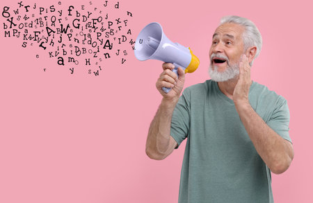 Man using megaphone on pink background. Letters flying out of device