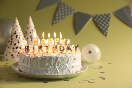 Tasty birthday cake with burning candles on green background, closeup. Space for textの写真素材