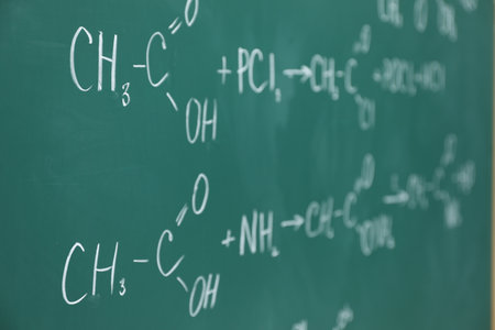 Chemical formulas written with chalk on green boardの写真素材