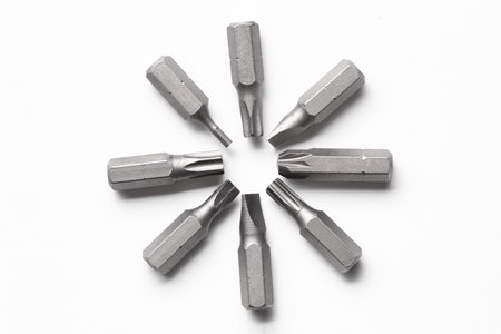 Different screwdriver bits on white background, top view