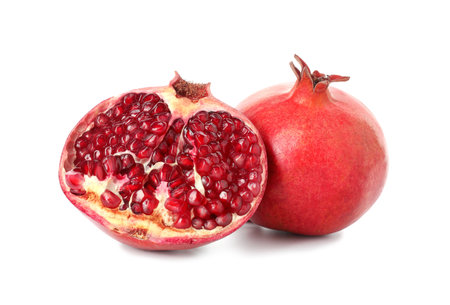Half and whole pomegranates isolated on whiteの写真素材