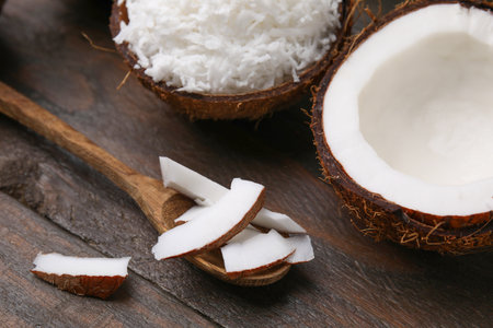 Coconut flakes, spoon and nut on wooden tableの写真素材