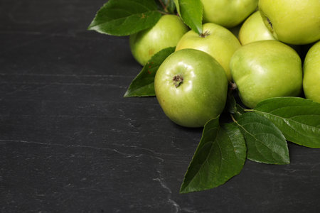 Ripe green apples with leaves on dark gray table. Space for textの写真素材