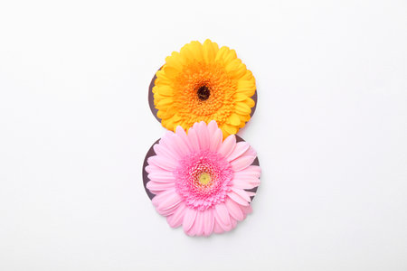 Number 8 shape hole in white paper with beautiful flowers, top view