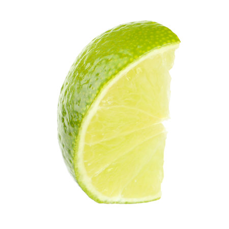 Slice of fresh green ripe lime isolated on whiteの写真素材