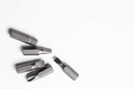 Different screwdriver bits on white background, top view