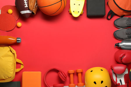 Frame made of different sports equipment on red background, flat lay. Space for textの写真素材