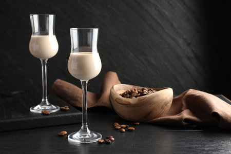 Coffee cream liqueur in glasses and beans on black wooden tableの写真素材