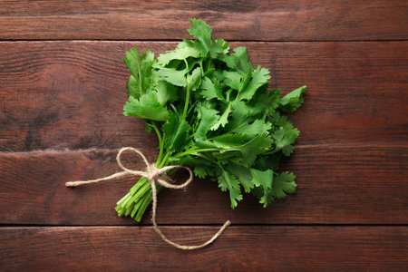 Bunch of fresh coriander on wooden table, top viewの写真素材