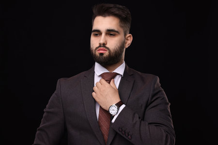 Handsome businessman in suit and necktie on black backgroundの写真素材