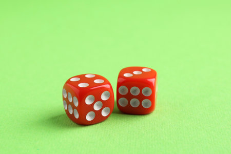 Two red game dices on green background, closeupの写真素材