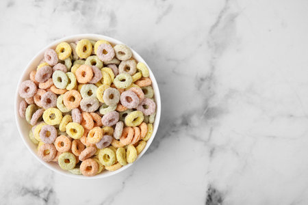 Tasty cereal rings in bowl on white marble table, top view. Space for textの写真素材