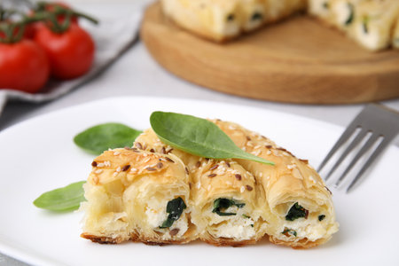 Piece of delicious puff pastry with spinach on table, closeupの写真素材