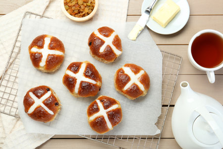 Tasty hot cross buns served on wooden table, flat lay