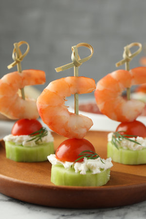 Tasty canapes with shrimps, vegetables and cream cheese on white table, closeupの写真素材