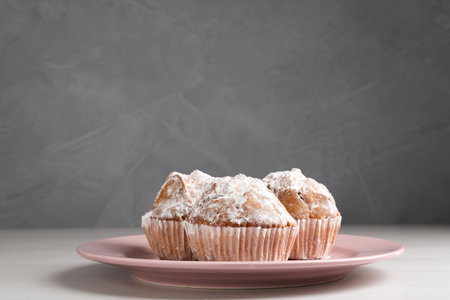 Tasty muffins with sugar powder on white wooden table, closeupの写真素材