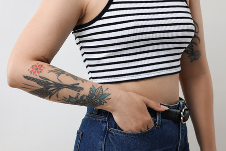 Woman with cool tattoos on gray background, closeupの写真素材