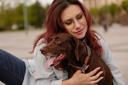 Woman with her cute German Shorthaired Pointer dog outdoorsの写真素材