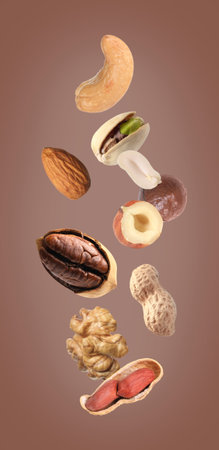 Mix of different nuts in air on brown backgroundの写真素材