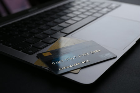 Laptop with credit cards on dark table, closeupの写真素材