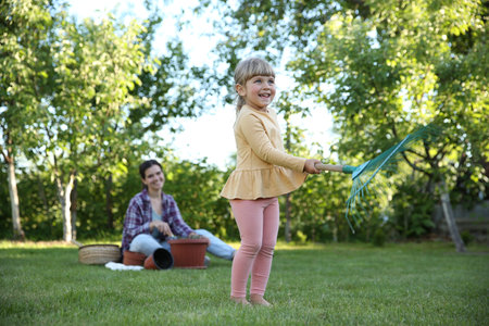 Mother and her daughter working together in garden