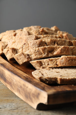 Freshly baked cut sourdough bread on wooden table, closeup