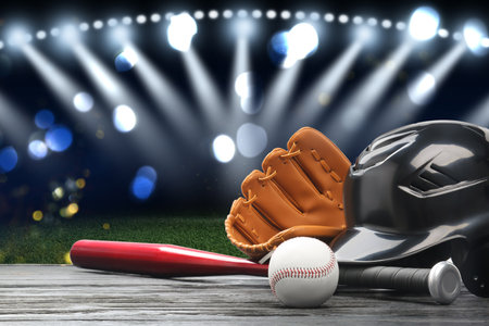Baseball bat, glove, helmet and ball on wooden table at stadium. Space for textの写真素材