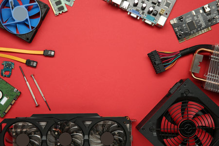 Frame of graphics card and other computer hardware on red background, flat lay. Space for textの写真素材