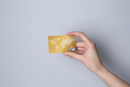 Woman holding credit card on light gray background, closeupの写真素材