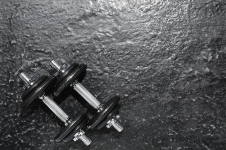 Barbells on dark textured floor, top view. Space for textの写真素材