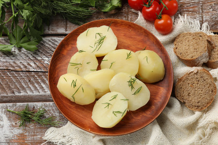 Plate with young boiled potatoes and dill on wooden rustic table, flat layの写真素材