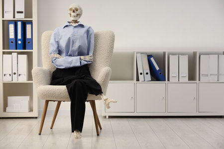 Waiting concept. Human skeleton sitting in armchair at office, space for textの写真素材