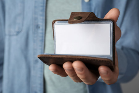 Man holding leather business card holder with blank card, closeupの写真素材