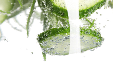 Refreshing cucumber water with bubbles isolated on white, closeupの写真素材