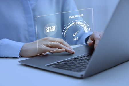 Speed test. Woman using laptop at table, closeup. Virtual screen over deviceの写真素材