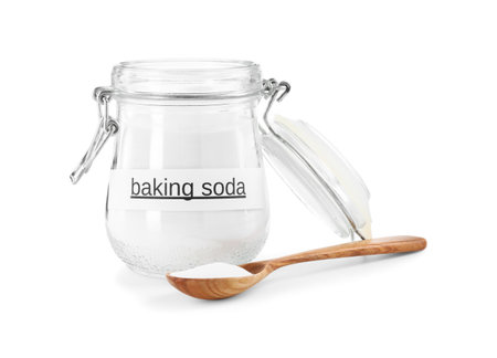 Baking soda in jar and spoon isolated on whiteの写真素材
